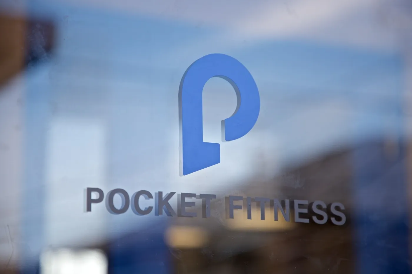 ガラス越しに見えるPOCKET FITNESSのロゴサイン